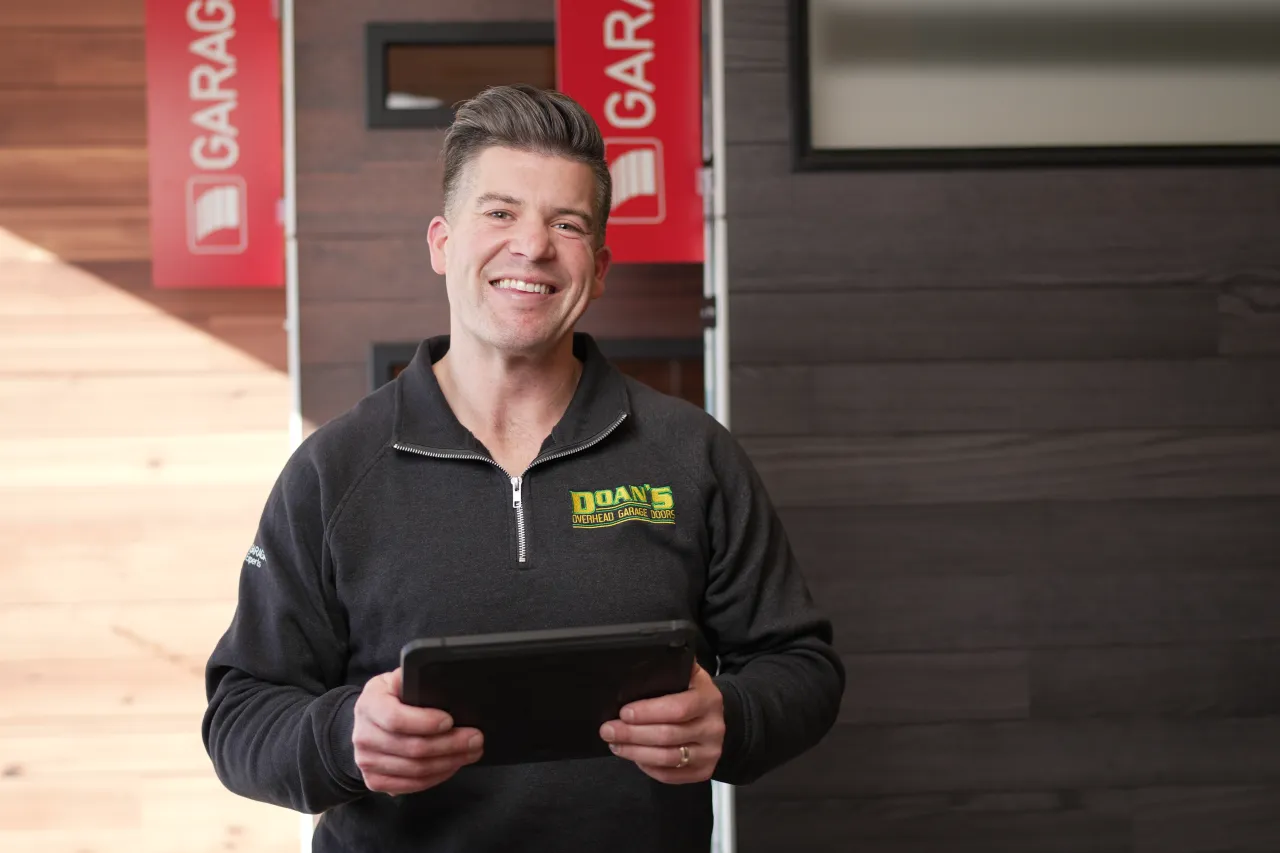 Garage door technician at Doan's Door with an ipad